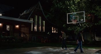 Movie still from “High School Musical 3: Senior Year” (2008), directed by Kenny Ortega – Two men playing basketball in a yard at night; Wide shot, High angle
