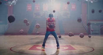 Movie still from “High School Musical 3: Senior Year” (2008), directed by Kenny Ortega – A man holding a basketball in a gym; Wide shot, Low angle