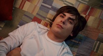 Movie still from “High School Musical 3: Senior Year” (2008), directed by Kenny Ortega – A man laying on the ground with his eyes closed; Close Up shot, Overhead angle