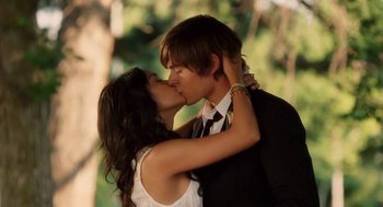 Movie still from “High School Musical 3: Senior Year” (2008), directed by Kenny Ortega – A man and a woman kissing each other in a forest; Close Up shot, Low angle