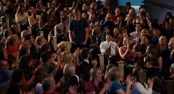 Movie still from “High School Musical 3: Senior Year” (2008), directed by Kenny Ortega – A crowd of people sitting and standing in a room; Wide shot, High angle