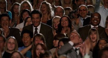 Movie still from “High School Musical 3: Senior Year” (2008), directed by Kenny Ortega – A group of people sitting in a crowd laughing; Medium shot, Over the shoulder angle