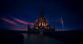 A large castle lit up at night with lights on it