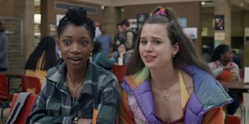 Movie still from “Honor Society” (2022), directed by Oran Zegman – Two young women sitting next to each other in a room; Close Up shot, Over the shoulder angle