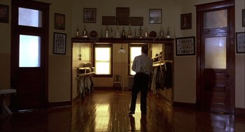 Movie still from “Hoosiers” (1986), directed by David Anspaugh – A man standing in the middle of a room; Wide shot, Low angle