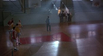Movie still from “Hoosiers” (1986), directed by David Anspaugh – A group of people standing in a gymnasium; Extreme Wide shot, High angle