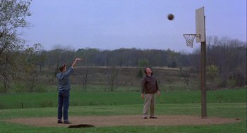 Movie still from “Hoosiers” (1986), directed by David Anspaugh – Two men are playing basketball on a dirt field; Wide shot, Low angle