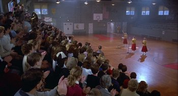 Movie still from “Hoosiers” (1986), directed by David Anspaugh – A crowd of people sitting in front of a basketball court; Extreme Wide shot, High angle