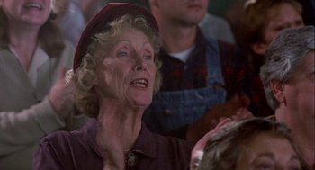 Movie still from “Hoosiers” (1986), directed by David Anspaugh – An older woman wearing a red hat is looking at something; Close Up shot, Low angle