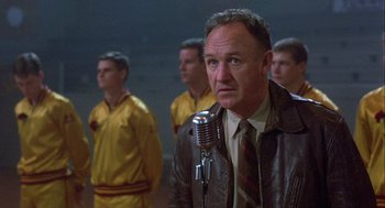 Movie still from “Hoosiers” (1986), directed by David Anspaugh – A group of men standing next to each other in a room; Medium shot, Low angle