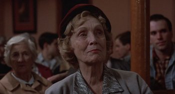 Movie still from “Hoosiers” (1986), directed by David Anspaugh – An older woman wearing a red hat looking up; Close Up shot, Low angle