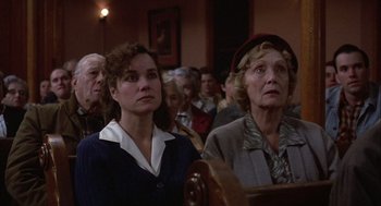Movie still from “Hoosiers” (1986), directed by David Anspaugh – Two women are sitting next to each other in front of an audience; Close Up shot, High angle
