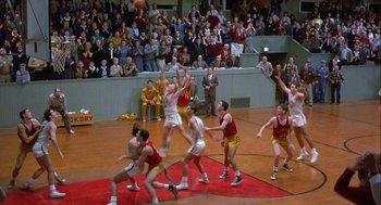 Movie still from “Hoosiers” (1986), directed by David Anspaugh – A group of young men playing a game of basketball; Extreme Wide shot, High angle