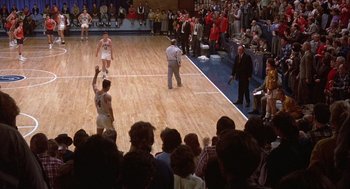 Movie still from “Hoosiers” (1986), directed by David Anspaugh – A crowd of people standing around a basketball court; Extreme Wide shot, High angle