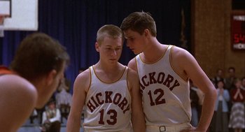 Movie still from “Hoosiers” (1986), directed by David Anspaugh – A couple of men standing next to each other; Medium shot, Over the shoulder angle