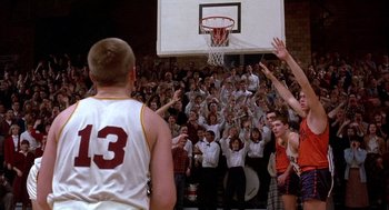 Movie still from “Hoosiers” (1986), directed by David Anspaugh – A group of young men standing in front of a basketball hoop; Wide shot, High angle