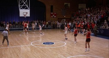 Movie still from “Hoosiers” (1986), directed by David Anspaugh – A group of young people playing a game of basketball; Extreme Wide shot, High angle