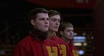 Movie still from “Hoosiers” (1986), directed by David Anspaugh – A group of young men standing next to each other; Close Up shot, Low angle