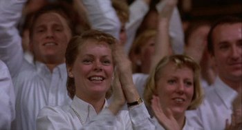Movie still from “Hoosiers” (1986), directed by David Anspaugh – A group of people sitting in a crowd clapping and smiling; Close Up shot, Low angle