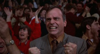 Movie still from “Hoosiers” (1986), directed by David Anspaugh – A man in a suit and tie with his mouth wide open; Close Up shot, Low angle