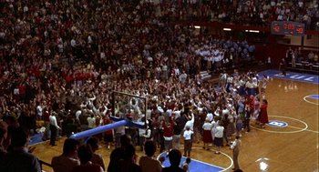 Movie still from “Hoosiers” (1986), directed by David Anspaugh – A crowd of people standing around a basketball court; Extreme Wide shot, High angle