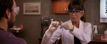 Movie still from “Horrible Bosses” (2011), directed by Seth Gordon – A woman in a white lab coat holding a pair of scissors; Close Up shot, Over the shoulder angle
