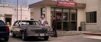 Movie still from “Horrible Bosses” (2011), directed by Seth Gordon – A man standing next to a car on the side of the street; Wide shot, Low angle