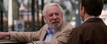 Movie still from “Horrible Bosses” (2011), directed by Seth Gordon – An older man with white hair sitting in a chair; Close Up shot, Over the shoulder angle