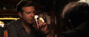 Movie still from “Horrible Bosses” (2011), directed by Seth Gordon – A person holding a glass of beer; Close Up shot, Over the shoulder angle