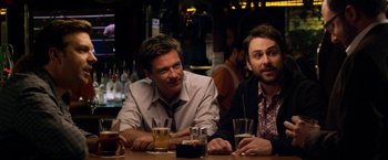 Movie still from “Horrible Bosses” (2011), directed by Seth Gordon – A couple of men sitting at a table with some drinks; Medium shot, Over the shoulder angle