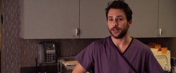 Movie still from “Horrible Bosses” (2011), directed by Seth Gordon – A man in a purple shirt is standing in a kitchen; Close Up shot, Over the shoulder angle