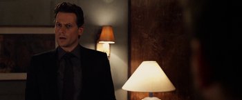 Movie still from “Horrible Bosses” (2011), directed by Seth Gordon – A man standing next to a lamp in a dark room; Close Up shot, Over the shoulder angle