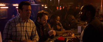 Movie still from “Horrible Bosses” (2011), directed by Seth Gordon – A group of men sitting at a table in a bar; Medium shot, Over the shoulder angle