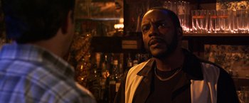 Movie still from “Horrible Bosses” (2011), directed by Seth Gordon – A man standing in front of a bar with bottles; Close Up shot, Low angle