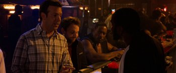 Movie still from “Horrible Bosses” (2011), directed by Seth Gordon – A group of men standing around a bar; Medium shot, Over the shoulder angle