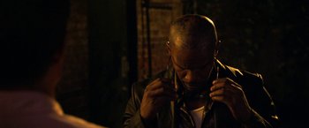 Movie still from “Horrible Bosses” (2011), directed by Seth Gordon – A man in a black leather jacket is fixing his ear buds; Close Up shot, High angle