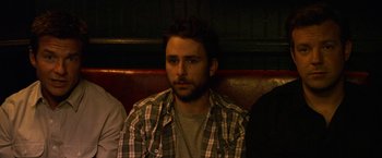 Movie still from “Horrible Bosses” (2011), directed by Seth Gordon – A man sitting on a couch in front of a window; Close Up shot, High angle