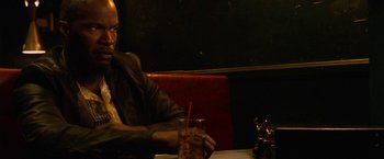Movie still from “Horrible Bosses” (2011), directed by Seth Gordon – A man sitting at a table with a drink in front of him; Close Up shot, Over the shoulder angle