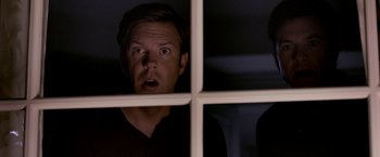 Movie still from “Horrible Bosses” (2011), directed by Seth Gordon – A man looking through a window at something; Close Up shot, Low angle
