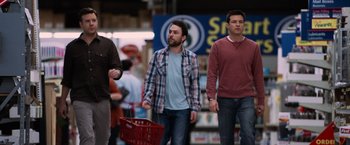 Movie still from “Horrible Bosses” (2011), directed by Seth Gordon – A group of men walking down a street with shopping carts; Medium shot, Over the shoulder angle