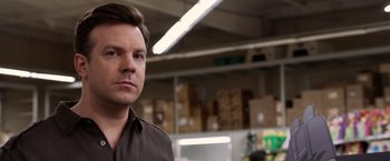 Movie still from “Horrible Bosses” (2011), directed by Seth Gordon – A man standing in a warehouse with boxes behind him; Close Up shot, Over the shoulder angle