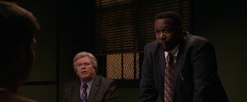 Movie still from “Horrible Bosses” (2011), directed by Seth Gordon – Two men in suits and ties sitting next to each other; Medium shot, Over the shoulder angle