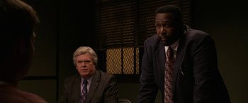 Movie still from “Horrible Bosses” (2011), directed by Seth Gordon – Two men in suits and ties sitting at a table; Medium shot, Over the shoulder angle