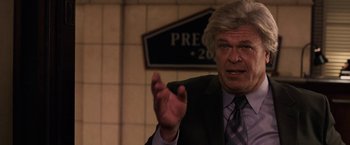 Movie still from “Horrible Bosses” (2011), directed by Seth Gordon – An older man wearing a suit and tie talking; Close Up shot, Over the shoulder angle