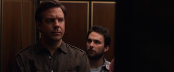 Movie still from “Horrible Bosses” (2011), directed by Seth Gordon – Two men standing next to each other in front of a door; Close Up shot, Over the shoulder angle