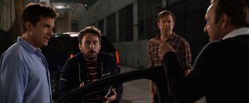 Movie still from “Horrible Bosses” (2011), directed by Seth Gordon – Two men in a parking lot talking to another man in the back of a car; Medium shot, Over the shoulder angle