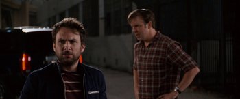 Movie still from “Horrible Bosses” (2011), directed by Seth Gordon – Two men standing next to each other on a street; Medium shot, Over the shoulder angle