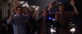 Movie still from “Horrible Bosses” (2011), directed by Seth Gordon – A group of young men standing next to each other on the street; Medium shot, Low angle