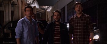 Movie still from “Horrible Bosses” (2011), directed by Seth Gordon – A group of men standing next to each other on a street; Medium shot, Over the shoulder angle