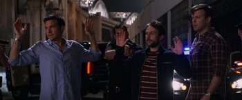 Movie still from “Horrible Bosses” (2011), directed by Seth Gordon – A group of men standing next to each other on a street; Medium shot, Over the shoulder angle